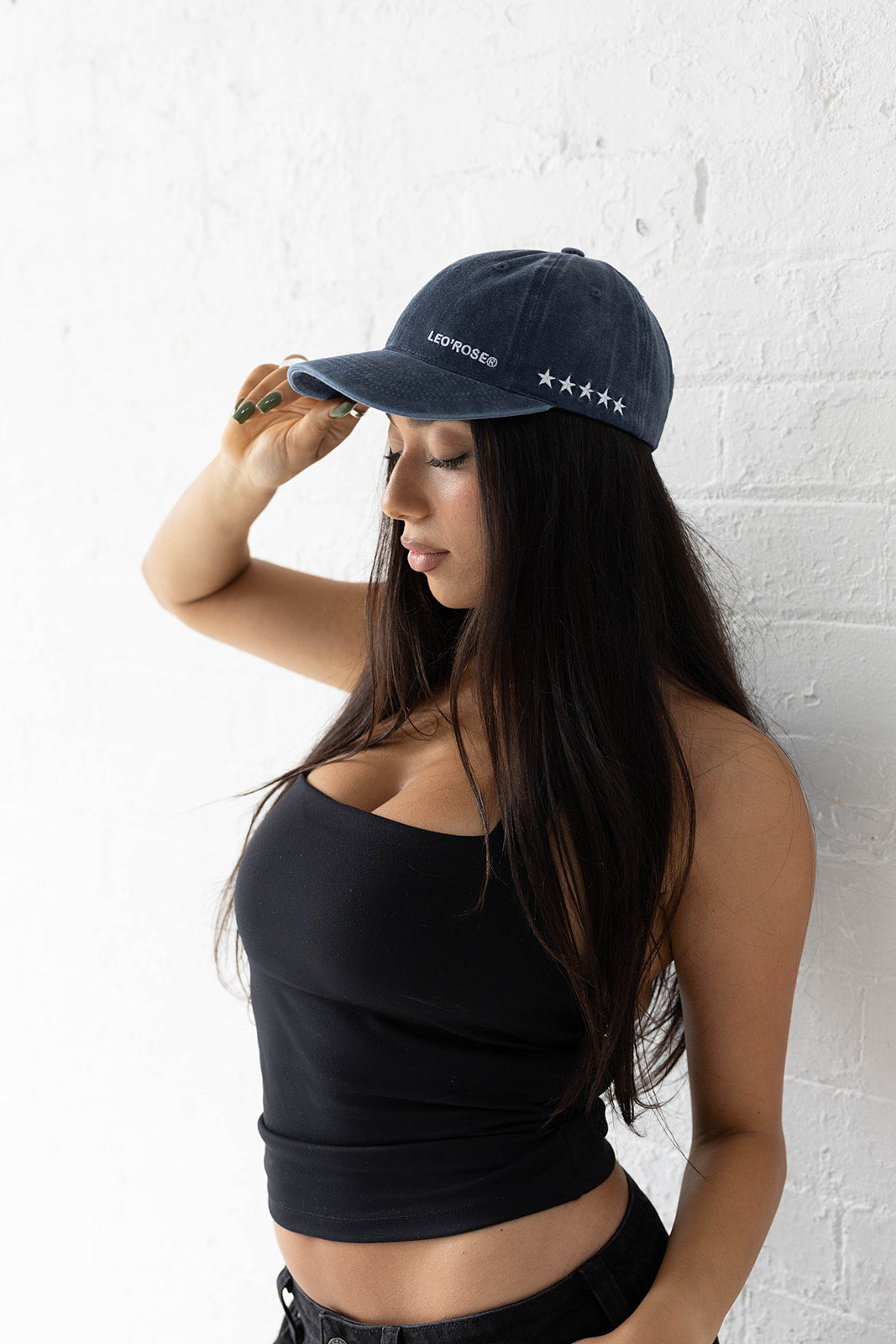 Woman in a LEO'ROSE hat in navy with LEO'ROSE text and stars