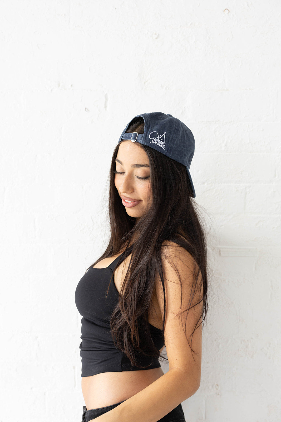 Woman in a LEO'ROSE hat in navy with LEO'ROSE text and stars